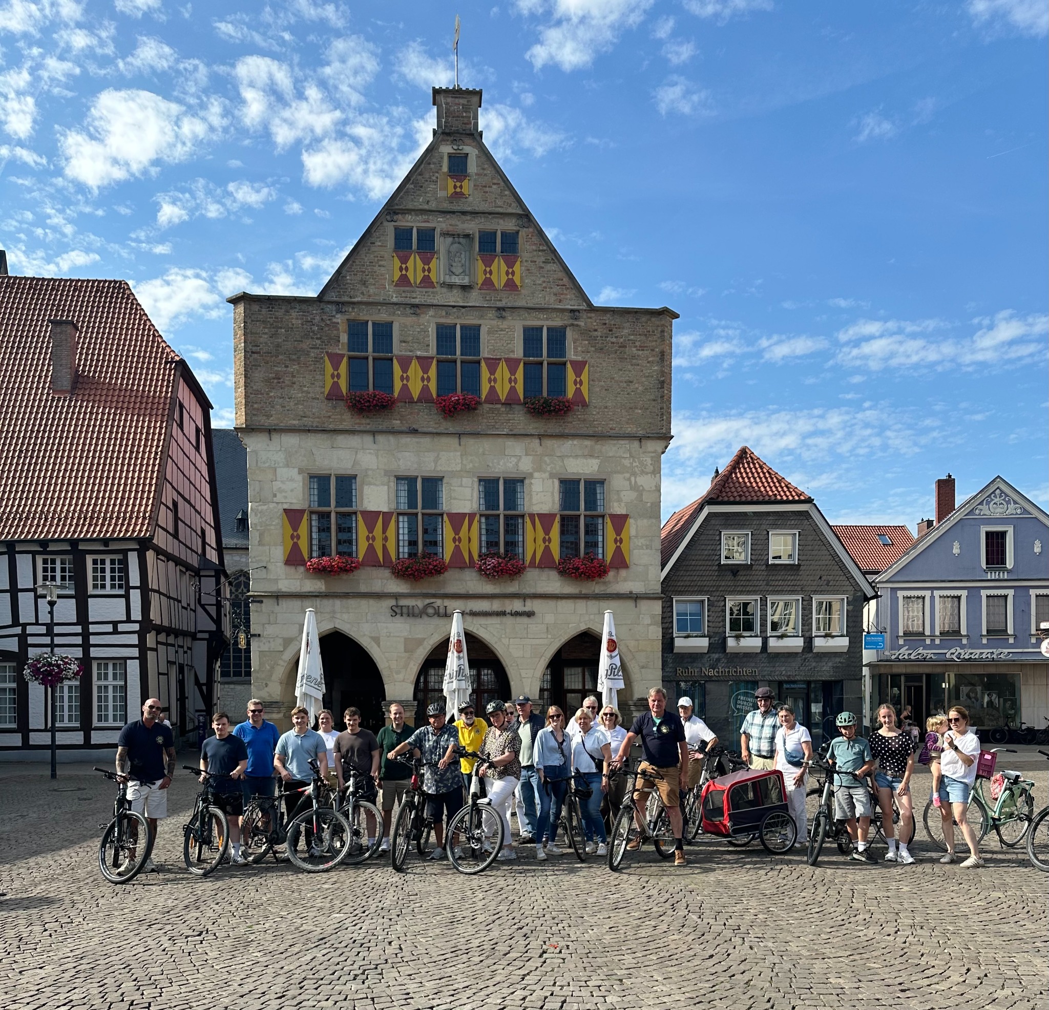 Mitglieder des Lions Clubs Werne an der Lippe und Leos bei der gemeinsamen Fahrradtour vor dem historischen Rathaus in Werne
